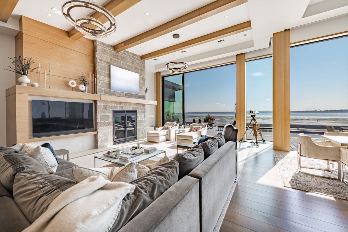 Luxury modern living room with floor-to-ceiling windows and stone fireplace